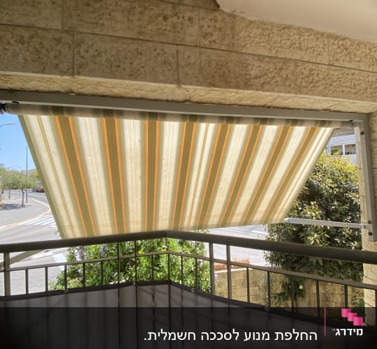 סוכך פסים צבעוני מותקן מעל מרפסת